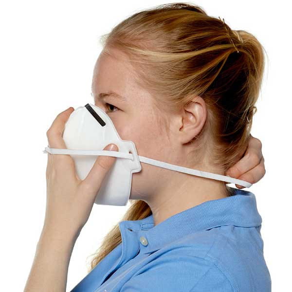 Atemschutzmaske wird ans Gesicht geführt.
