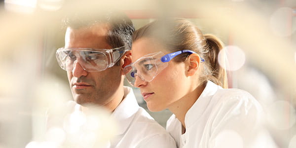 Mann und Frau tragen eine Augenschutzbrille im Labor